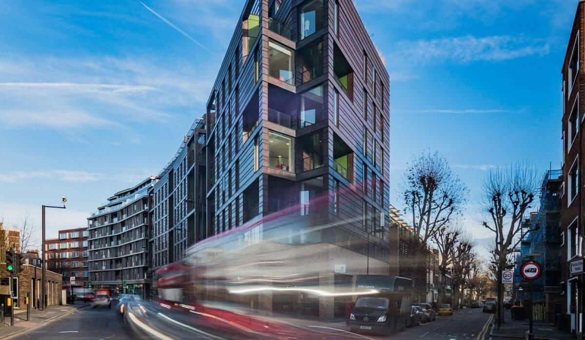 Exterior of modern building in Hoxton with buses rushing past