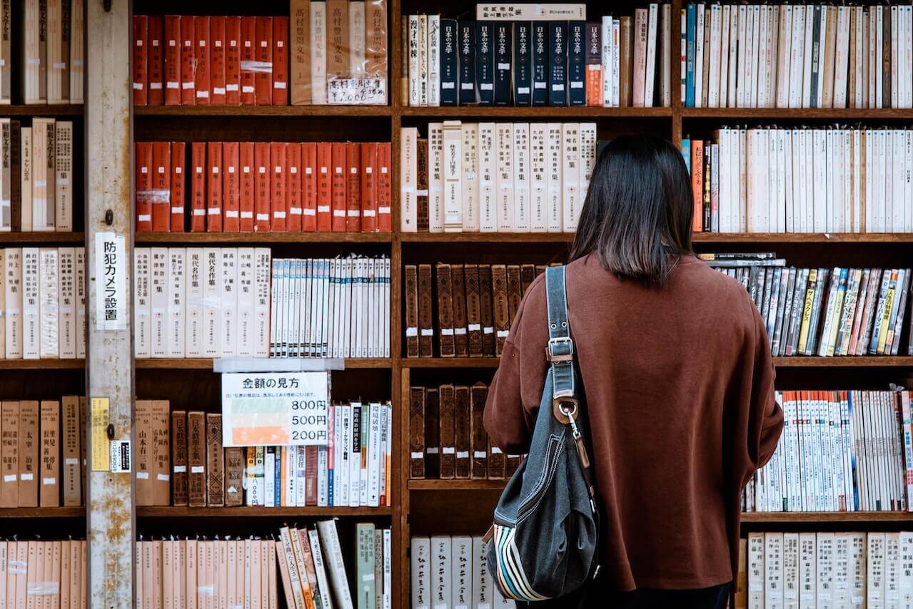 Student looking at books in library 