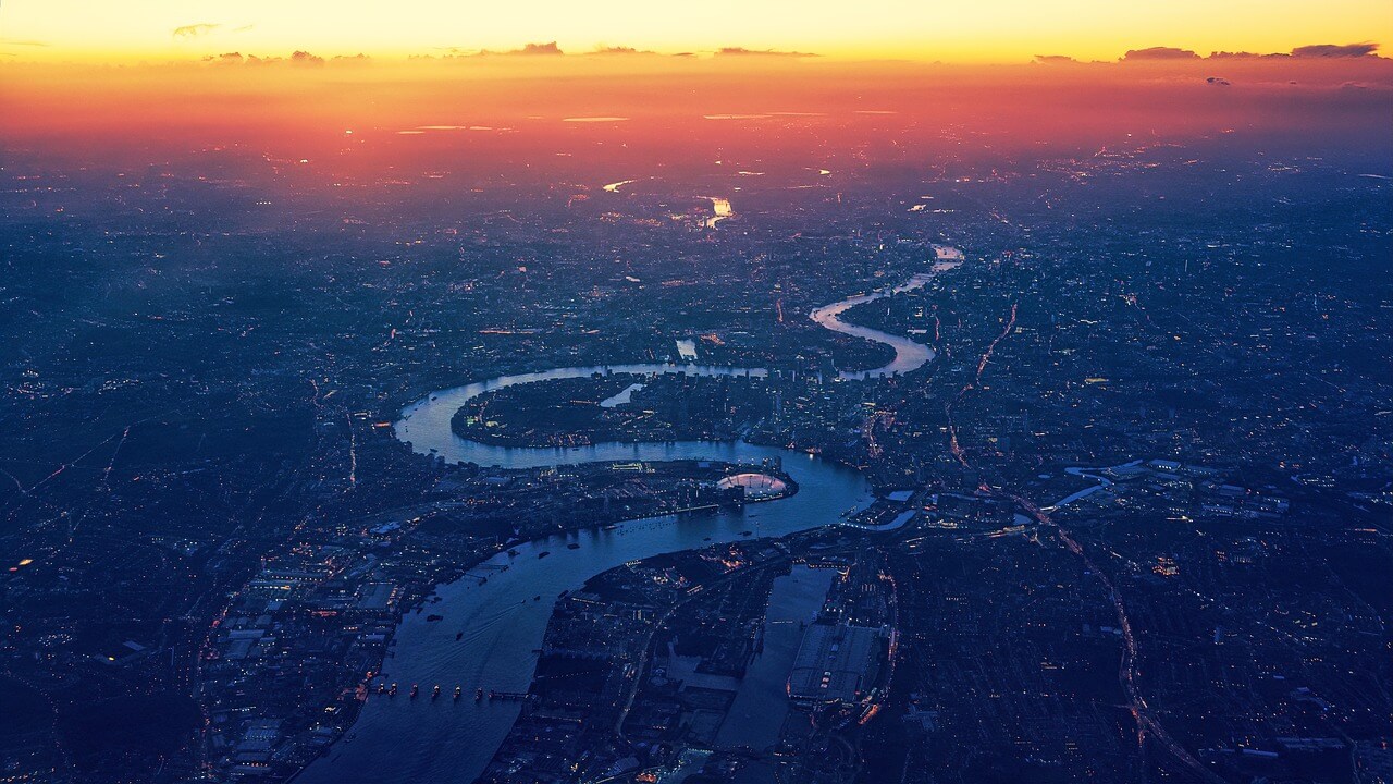 An aerial shot of the River Thames as it runs through London at sunrise.