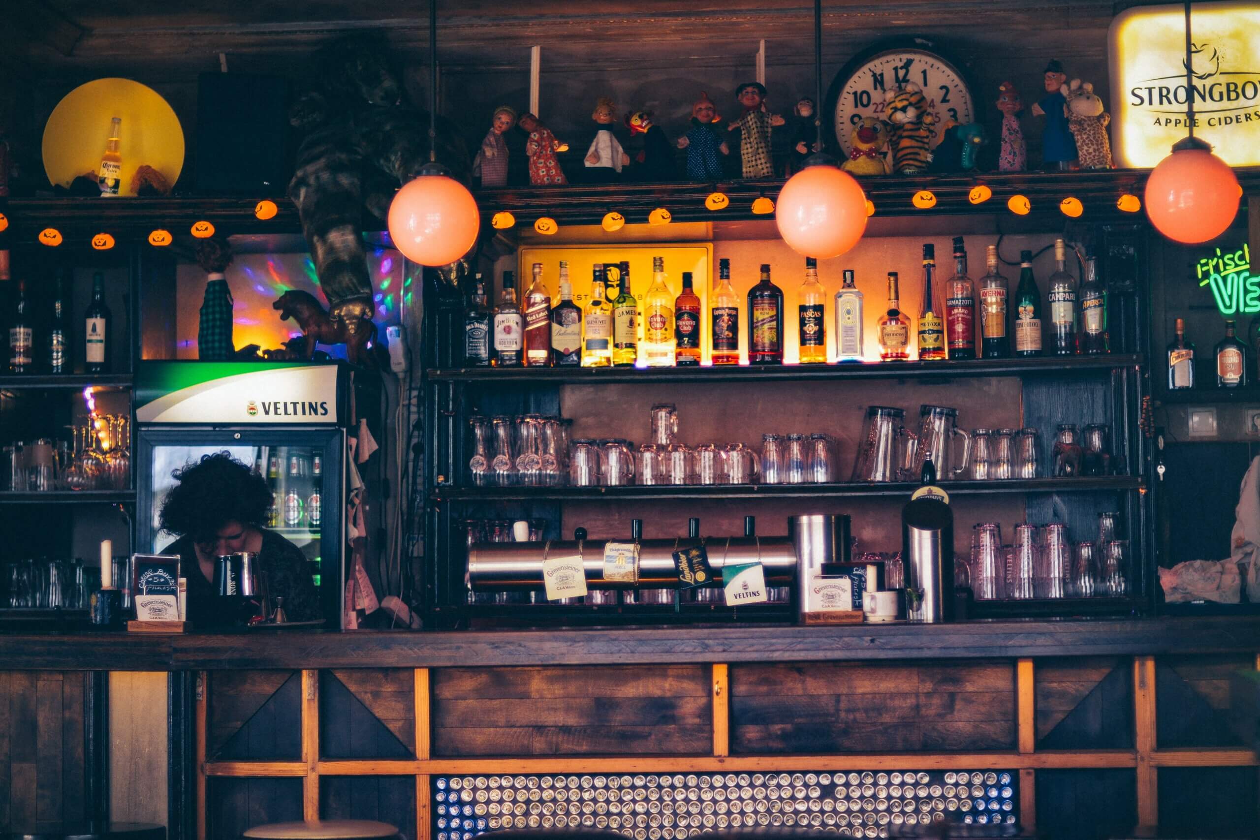 Picture of a bar at a pub with bottles of liquor and empty glasses.