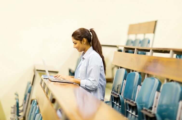 Student sitting at the end of the row in a lecture hall